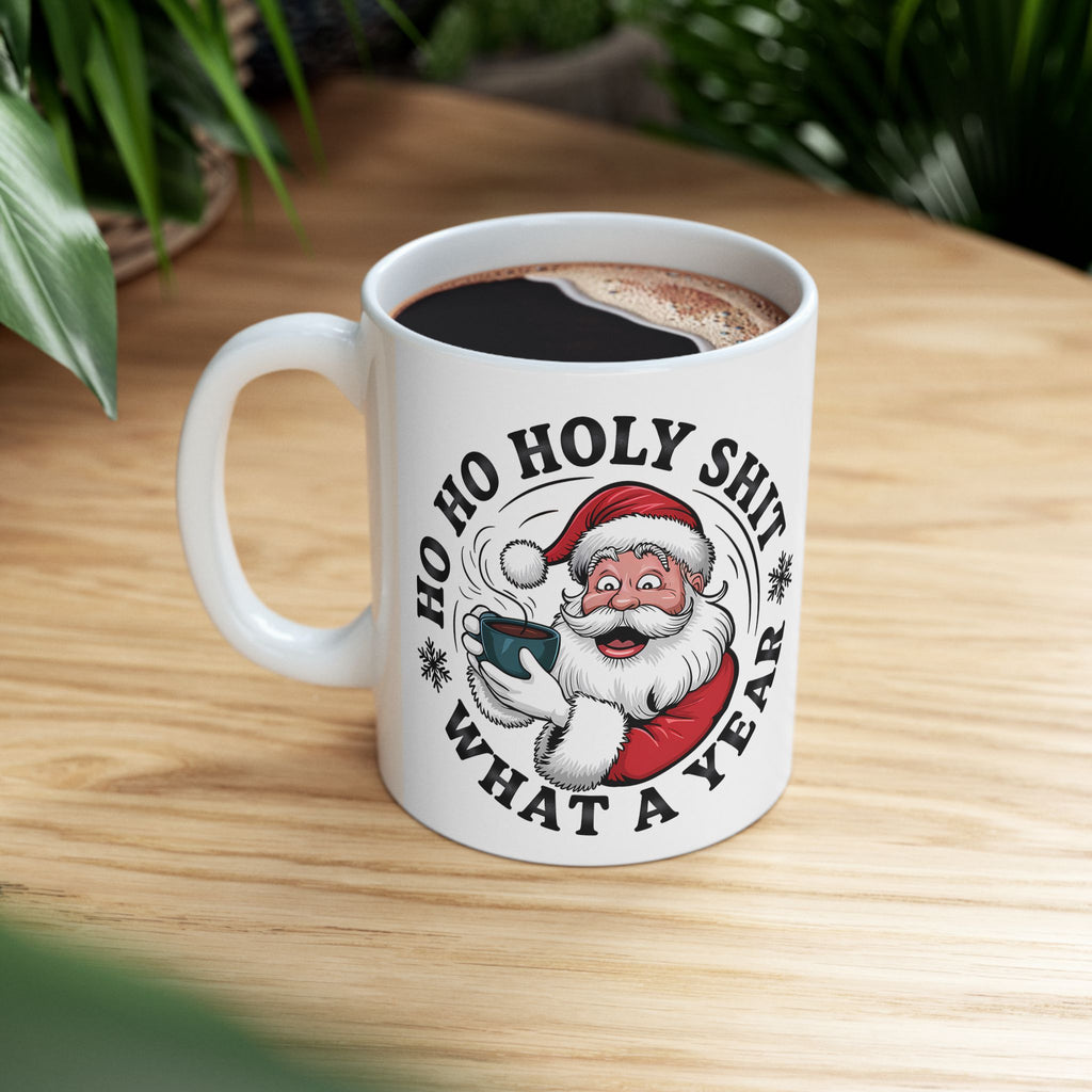 White mug with Santa Claus graphic and text on a wooden table